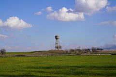 Zementwasserbehälter auf einem grünen Korngebiet stockfotografie Zementwasserbehälter auf einem grünen Korngebiet stockfotografie