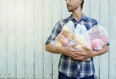 Zero ja?owy zakupy poj?cie Modnisia mężczyzna trzyma reusable eco zdojest z świeżymi owoc Zakazu use pojedynczy klingeryt zdjęcia stock Zero ja?owy zakupy poj?cie Modnisia mężczyzna trzyma reusable eco zdojest z świeżymi owoc Zakazu use pojedynczy klingeryt zdjęcia stock