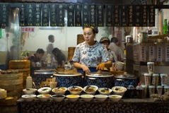 ZHOUZHUANG, ΚΙΝΑ: Ένα κατάστημα τροφίμων στα παραδοσιακά πολιτιστικά πωλώντας ζεστά τρόφιμα και το ποτό προσδιορισμού στοκ εικόνα με δικαίωμα ελεύθερης χρήσης ZHOUZHUANG, ΚΙΝΑ: Ένα κατάστημα τροφίμων στα παραδοσιακά πολιτιστικά πωλώντας ζεστά τρόφιμα και το ποτό προσδιορισμού στοκ εικόνα με δικαίωμα ελεύθερης χρήσης