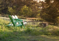 Zieleni krzesła ogrodowe pożarniczą jamą fotografia stock Zieleni krzesła ogrodowe pożarniczą jamą fotografia stock