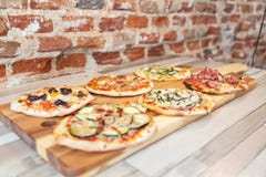 Zijaanzicht van zes verschillende pizza's op een houten raad stock foto Zijaanzicht van zes verschillende pizza's op een houten raad stock foto