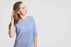 Zijdelings geschoten van nadenkende modieuze vrouw houdt hand op haar, heeft nadenkende uitdrukking, draagt gestreepte kleren, mo royalty-vrije stock afbeeldingen Zijdelings geschoten van nadenkende modieuze vrouw houdt hand op haar, heeft nadenkende uitdrukking, draagt gestreepte kleren, mo royalty-vrije stock afbeeldingen