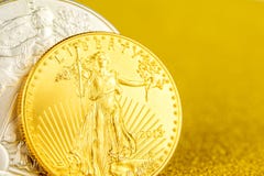 Zilveren adelaar en gouden Amerikaanse adelaar één onsmuntstukken op gouden achtergrond stock foto's Zilveren adelaar en gouden Amerikaanse adelaar één onsmuntstukken op gouden achtergrond stock foto's