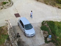 Zilveren vijfdeursautoauto, lopende mens en het drinken fontein in de vierkante, hoogste mening Creatieve luchtfoto, wegdek met e royalty-vrije stock fotografie Zilveren vijfdeursautoauto, lopende mens en het drinken fontein in de vierkante, hoogste mening Creatieve luchtfoto, wegdek met e royalty-vrije stock fotografie