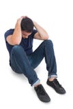 Zittende verstoorde mens met handen achter hoofd stock fotografie Zittende verstoorde mens met handen achter hoofd stock fotografie