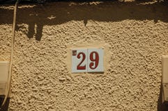 Znak uliczny z numerowy dwadzieścia dziewięć w ścianie przy Merida obrazy stock Znak uliczny z numerowy dwadzieścia dziewięć w ścianie przy Merida obrazy stock