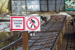 Znaka ostrzegawczego «ostrożność niebezpieczeństwo strefa w rosjaninie « Nagłego wypadku most w tle Wizerunek zdjęcie stock Znaka ostrzegawczego «ostrożność niebezpieczeństwo strefa w rosjaninie « Nagłego wypadku most w tle Wizerunek zdjęcie stock