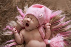 Zoete pasgeboren baby in roze GLB-geeuwen en rek, kielzog royalty-vrije stock fotografie Zoete pasgeboren baby in roze GLB-geeuwen en rek, kielzog royalty-vrije stock fotografie