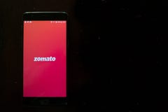 Zomato app показало черный телефон на темной текстуре - поставке app еды стоковые изображения Zomato app показало черный телефон на темной текстуре - поставке app еды стоковые изображения