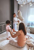Zrelaksowana matka i synowie bawić się nad łóżkiem zdjęcie stock Zrelaksowana matka i synowie bawić się nad łóżkiem zdjęcie stock