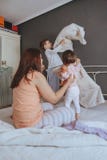Zrelaksowana matka i synowie bawić się nad łóżkiem Fotografia Stock Zrelaksowana matka i synowie bawić się nad łóżkiem Fotografia Stock
