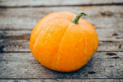 Zucca arancio di autunno piccola su di legno fotografia stock libera da diritti Zucca arancio di autunno piccola su di legno fotografia stock libera da diritti