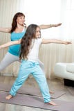 Zwanger mamma die prenatale yoga met haar doen weinig dochter bij hom stock afbeelding Zwanger mamma die prenatale yoga met haar doen weinig dochter bij hom stock afbeelding