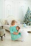 Zwangere Europese vrouw die blauwe kleding dragen die buik koesteren en met weinig dochter dichtbij Kerstboom in slaapkamer zitte stock afbeeldingen Zwangere Europese vrouw die blauwe kleding dragen die buik koesteren en met weinig dochter dichtbij Kerstboom in slaapkamer zitte stock afbeeldingen