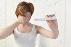 Zwangere vrouw die roze positieve zwangerschapstest houden die haar ogen behandelen met haar hand royalty-vrije stock afbeelding Zwangere vrouw die roze positieve zwangerschapstest houden die haar ogen behandelen met haar hand royalty-vrije stock afbeelding