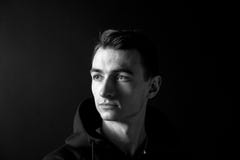 Zwart-wit portret die van een jonge mens, aan de kant, tegen duidelijke studioachtergrond kijken stock afbeeldingen Zwart-wit portret die van een jonge mens, aan de kant, tegen duidelijke studioachtergrond kijken stock afbeeldingen