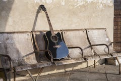 Zwarte akoestische gitaar op de oude sjofele stoelen Stock Foto's Zwarte akoestische gitaar op de oude sjofele stoelen Stock Foto's