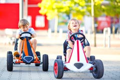 Zwei aktive Kleinkindjungen, die Pedalrennwagen im Sommergarten, draußen fahren Kinder, beste Freunde, die mit schnellem laufen stockfotos Zwei aktive Kleinkindjungen, die Pedalrennwagen im Sommergarten, draußen fahren Kinder, beste Freunde, die mit schnellem laufen stockfotos