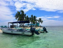 Zwei Boote verankert in der Untiefe der Tropeninsel des lachenden Vogels Caye lizenzfreie stockfotos Zwei Boote verankert in der Untiefe der Tropeninsel des lachenden Vogels Caye lizenzfreie stockfotos