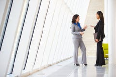 Zwei Geschäftsfrauen, die informelle Sitzung im modernen Büro haben Lizenzfreies Stockfoto Zwei Geschäftsfrauen, die informelle Sitzung im modernen Büro haben Lizenzfreies Stockfoto