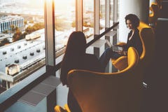Zwei Geschäftsfrauen, welche die Arbeit sich trifft nahe Bürofenstern haben lizenzfreie stockfotografie Zwei Geschäftsfrauen, welche die Arbeit sich trifft nahe Bürofenstern haben lizenzfreie stockfotografie