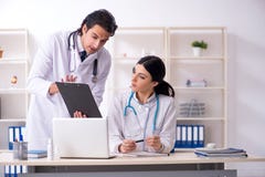 Zwei junge Doktoren, die in der Klinik arbeiten lizenzfreies stockbild Zwei junge Doktoren, die in der Klinik arbeiten lizenzfreies stockbild