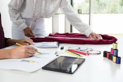 Zwei junges Damenschneiderin- oder Designerkollegen Arbeiten und discussi stockbild Zwei junges Damenschneiderin- oder Designerkollegen Arbeiten und discussi stockbild