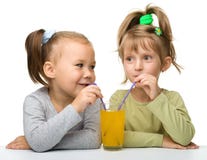 Zwei kleine Mädchen trinken Orangensaft stockbild Zwei kleine Mädchen trinken Orangensaft stockbild