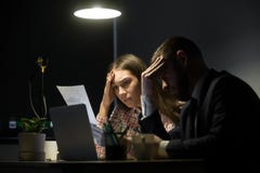 Zwei Kollegen, die schlechten Umgang betrachten, berichten in der Abendsitzung lizenzfreies stockfoto Zwei Kollegen, die schlechten Umgang betrachten, berichten in der Abendsitzung lizenzfreies stockfoto