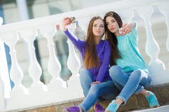 Zwei Mädchen, die Musik auf ihren Smartphones hören lizenzfreies stockfoto Zwei Mädchen, die Musik auf ihren Smartphones hören lizenzfreies stockfoto