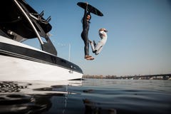 Zwei Mädchen, die zum Fluss mit wakeboard springen lizenzfreies stockbild Zwei Mädchen, die zum Fluss mit wakeboard springen lizenzfreies stockbild