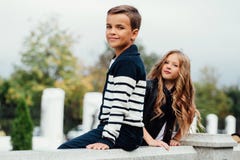 Zwei nette Kinder sitzen auf dem Geländer Marmor-Steinbrunnen lizenzfreie stockbilder Zwei nette Kinder sitzen auf dem Geländer Marmor-Steinbrunnen lizenzfreie stockbilder