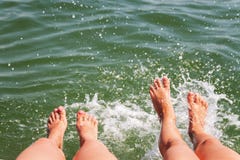 Zwei Paare Fußspritzen im Wasser lizenzfreie stockbilder Zwei Paare Fußspritzen im Wasser lizenzfreie stockbilder