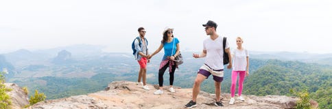 Zwei touristische Paare mit Rucksack auf der Gebirgsspitzenunterhaltung über schöner Landschaftspanorama-Ansicht stockbild Zwei touristische Paare mit Rucksack auf der Gebirgsspitzenunterhaltung über schöner Landschaftspanorama-Ansicht stockbild