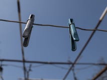 Zwei Wäscheklammern, die an einem Seil auf der Straße gegen einen blauen Himmel hängen stockfotos Zwei Wäscheklammern, die an einem Seil auf der Straße gegen einen blauen Himmel hängen stockfotos
