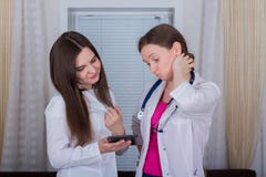 Zwei Ärztinnen oder Krankenschwestern betrachten die Tablette und besprechen Therapie lizenzfreies stockbild Zwei Ärztinnen oder Krankenschwestern betrachten die Tablette und besprechen Therapie lizenzfreies stockbild