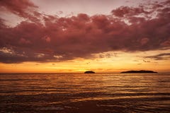 Złoty zmierzch na plaży z zmrok chmurami i wieczór łuną Denny odbicia czerwone światło jak wsch fotografia stock Złoty zmierzch na plaży z zmrok chmurami i wieczór łuną Denny odbicia czerwone światło jak wsch fotografia stock