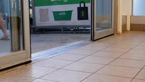 Ángulo bajo de la gente con caminar a través de las puertas en el superstore almacen de metraje de vídeo Ángulo bajo de la gente con caminar a través de las puertas en el superstore almacen de metraje de vídeo