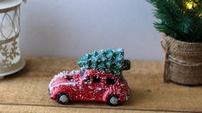 Árbol de navidad que lleva del coche rojo del juguete en el tejado fotografía de archivo Árbol de navidad que lleva del coche rojo del juguete en el tejado fotografía de archivo