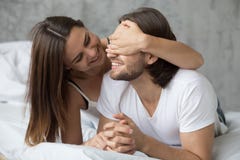 Älska kvinnabokslut mans ögon med händer som spelar i säng royaltyfri foto Älska kvinnabokslut mans ögon med händer som spelar i säng royaltyfri foto