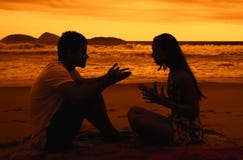 Älska par med förhållandesvårigheter på stranden på solnedgången arkivfoto Älska par med förhållandesvårigheter på stranden på solnedgången arkivfoto