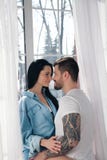 Älska par som kramar på fönstret mycket gullig och härlig grabb och flicka royaltyfri fotografi Älska par som kramar på fönstret mycket gullig och härlig grabb och flicka royaltyfri fotografi