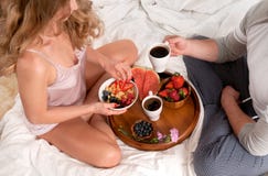 Älskvärda barnpar som har frukosten i säng royaltyfri foto Älskvärda barnpar som har frukosten i säng royaltyfri foto