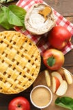 Äppelpaj med galleröverkanten och ingredienser på trätabellen fotografering för bildbyråer Äppelpaj med galleröverkanten och ingredienser på trätabellen fotografering för bildbyråer