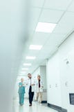 Ärzteteam im Krankenhauskorridor Arbeit besprechend lizenzfreies stockfoto Ärzteteam im Krankenhauskorridor Arbeit besprechend lizenzfreies stockfoto