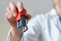 Ärztin, welche in der Hand die Stempel sich vorbereiten zu versiegeln, Nahaufnahmetrieb hält lizenzfreies stockbild Ärztin, welche in der Hand die Stempel sich vorbereiten zu versiegeln, Nahaufnahmetrieb hält lizenzfreies stockbild
