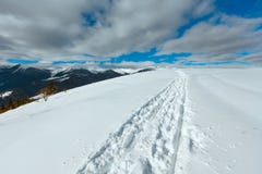 Åka släde spåret och fotspår på överkant för vinterbergkulle Royaltyfri Bild Åka släde spåret och fotspår på överkant för vinterbergkulle Royaltyfri Bild