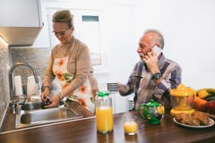 Åldringpar i köket som förbereder frukosten royaltyfri bild Åldringpar i köket som förbereder frukosten royaltyfri bild