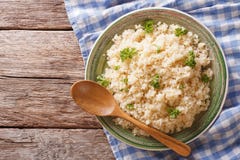 Ångad bulgur med persiljanärbild på en platta på tabellen Ho royaltyfri bild Ångad bulgur med persiljanärbild på en platta på tabellen Ho royaltyfri bild
