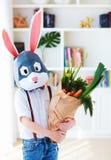 Śliczna elegancka chłopiec w poligonalnej Easter królika masce z torbą świeża wiosna, pełno zielenieje zdjęcia stock Śliczna elegancka chłopiec w poligonalnej Easter królika masce z torbą świeża wiosna, pełno zielenieje zdjęcia stock